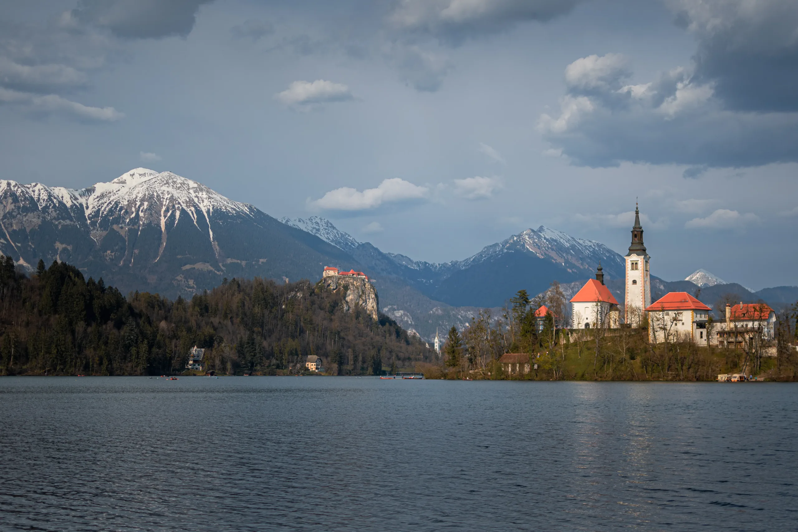 Bledi látkép a templommal és a havas hegyekkel