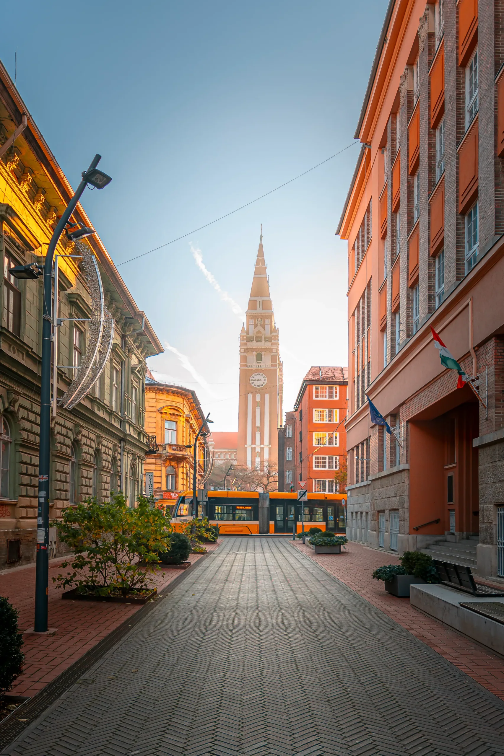 A dóm a kora reggeli napsütésben előtte elsuhanó villamossal.