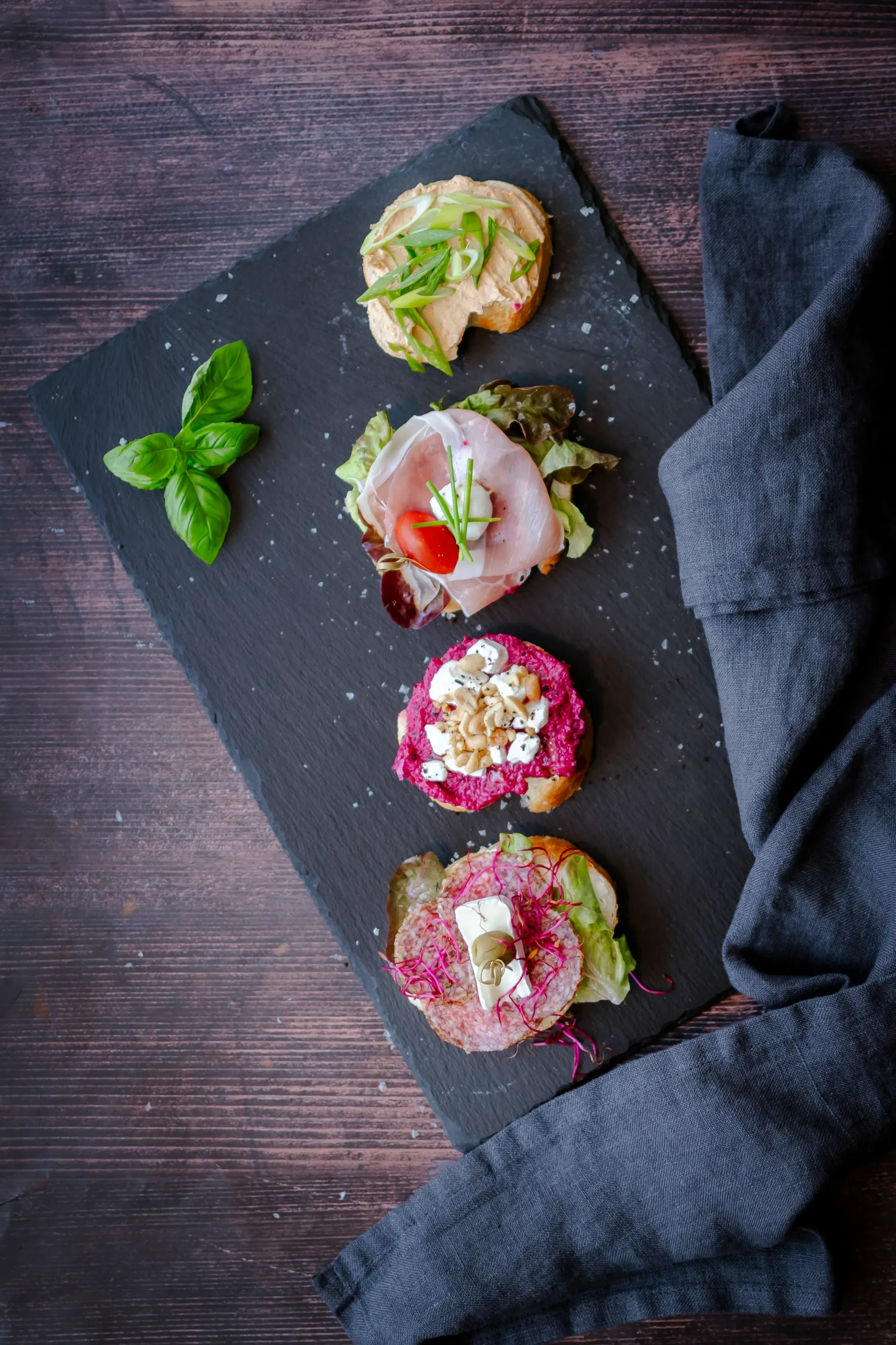 Szendvicsek palatáblán bazsalikommal és konyharuhával