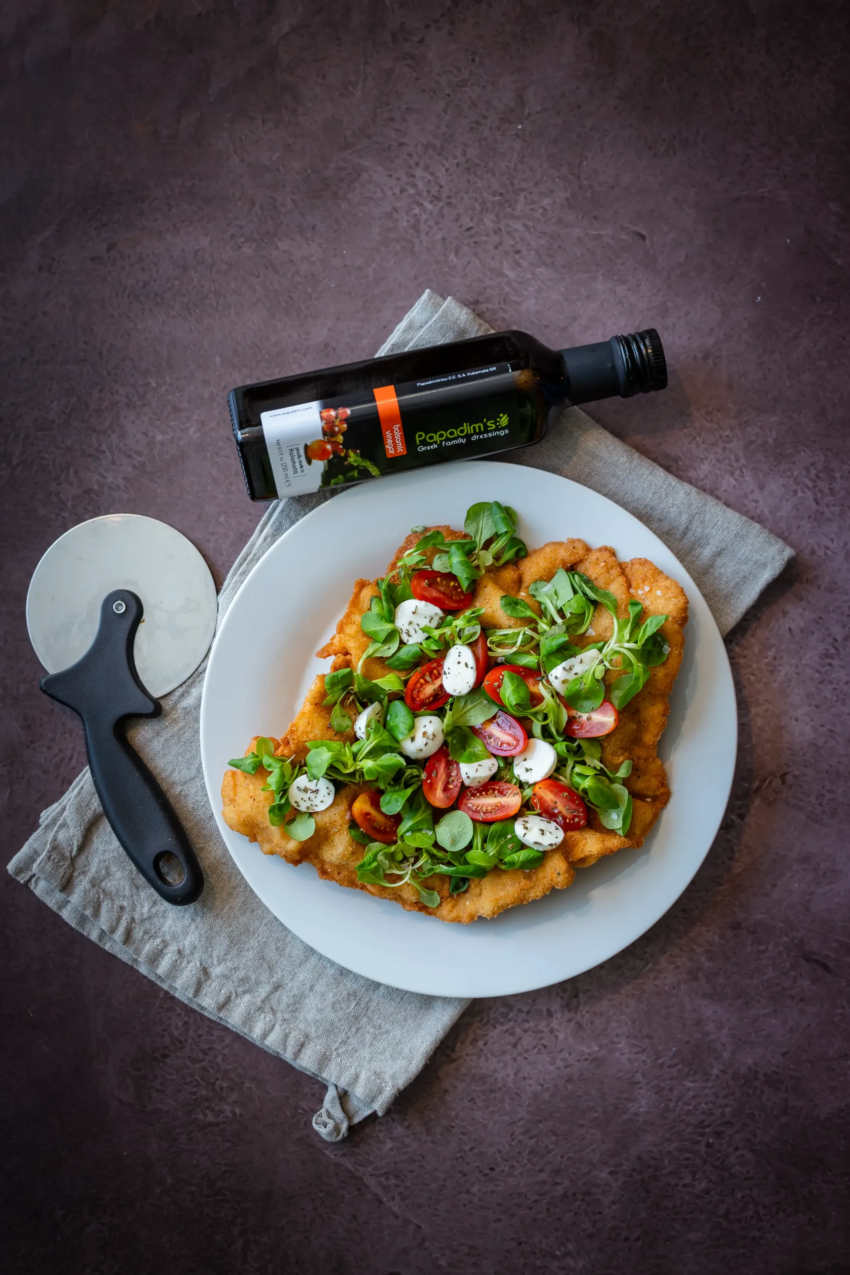 Óriás rántott szelet, rajta mozzarella paradicsom és saláta.